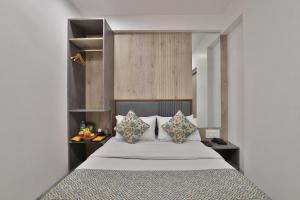 Un pat sau paturi într-o cameră la 7 Orbit Hotel, Surat