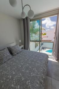 a bedroom with a bed and a view of a balcony at Vv Sunny Holiday Villa Maspalomas in Maspalomas