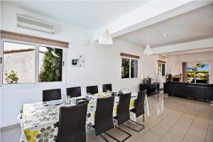 uma sala de jantar com uma mesa longa e cadeiras em Carilisto Villas Big 4 Bedrooms in Center of Ayia Napa em Agia Napa