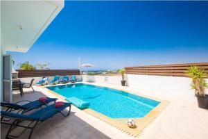 uma piscina num pátio com cadeiras e o oceano em Carilisto Villas Big 4 Bedrooms in Center of Ayia Napa em Agia Napa
