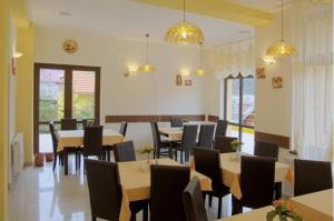 a dining room with tables and chairs and lights at Flora Alpina in Azuga