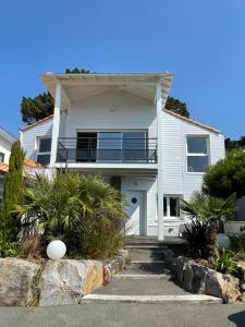 Dieses weiße Haus verfügt über eine Veranda und einen Balkon. in der Unterkunft Coté Ouest in Pornic