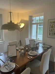 mesa de comedor con sillas blancas y lámpara en Villa Amselgrund, en Rathen