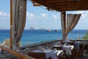 a restaurant with a view of the ocean at Vrahos Boutique Hotel in Karavostasi