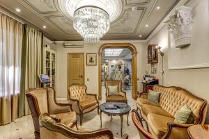 a living room with a couch and chairs and a chandelier at Pushka INN hotel in Saint Petersburg