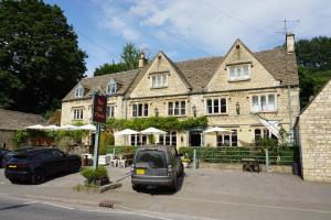 a car parked in front of a large building at The Coach House and The Stable in Woodchester