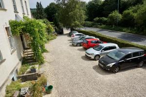 a row of cars parked in a driveway next to a building at The Coach House and The Stable in Woodchester