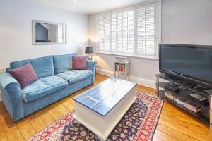 a living room with a blue couch and a flat screen tv at Host & Stay - Kulla Loft in Harrogate