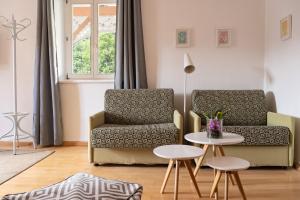 ein Wohnzimmer mit 2 Stühlen und einem Tisch in der Unterkunft Absteige Innsbruck- Zentrale Ferienapartments in Innsbruck