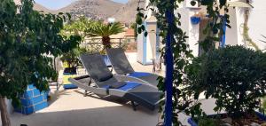 two lounge chairs on a patio with mountains in the background at La Casa di Chico in Mondello