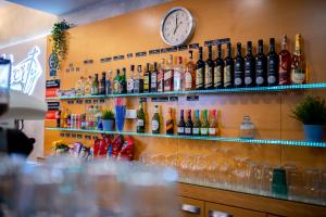 eine Bar mit Alkoholflaschen und eine Uhr an der Wand in der Unterkunft Felicity Garni Hotel in Bratislava