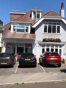 three cars parked in a parking lot in front of a house at Swanage Haven Boutique Guest House in Swanage