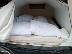 a bed in a tent with white pillows at Basic 2p tent Sotterum in Cornwerd