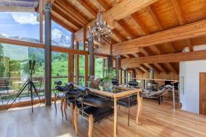 uma sala de jantar com uma mesa de vidro e cadeiras de couro em Suitenhotel Zurbriggen em Zermatt