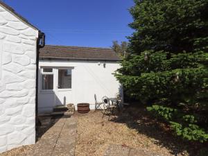 a white cottage with a table and chairs in a yard at Solway Cottage in Annan