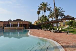 a swimming pool with chairs and umbrellas in a resort at casa pipoca in Lagos