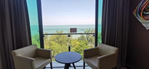 a room with two chairs and a table and a large window at Dwharf Seaview Executive Suit PortDickson in Port Dickson