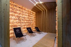 uma fila de cadeiras num quarto com uma parede de tijolos em Apartamenty Sun & Snow Kalinowa z sauną em Szczyrk