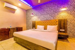 a bedroom with a large bed with purple lights at FabHotel Rudra Inn & Cafe in Gorakhpur