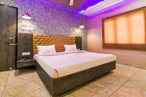 a bedroom with a large bed in a room at FabHotel Rudra Inn & Cafe in Gorakhpur
