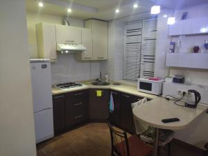 a small kitchen with white appliances and a table at EAA in Tiraspol
