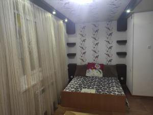 a bedroom with a bed and a wall with curtains at EAA in Tiraspol