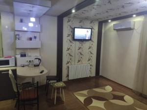 a kitchen with a table and a television on a wall at EAA in Tiraspol