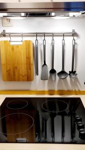 a kitchen stove with utensils hanging on a wall at La cave de Nana in Liège