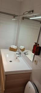 a bathroom with a white sink and a mirror at La cave de Nana in Liège +10 photos