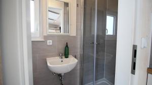 uma casa de banho com um lavatório e um chuveiro em Tiny Hotel Herdt em Reichenberg