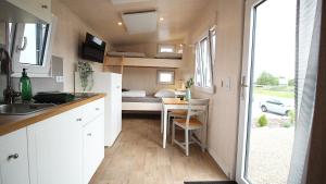 a kitchen and dining area of a tiny house at Tiny Hotel Herdt in Reichenberg