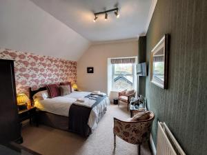 - une chambre avec un lit, une chaise et une fenêtre dans l'établissement 1 Park Road, à Windermere
