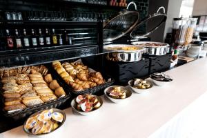 a buffet line with different types of pastries and bread at B&B HOTEL Basel in Basel