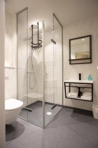 a bathroom with a shower and a toilet and a sink at Hotel - B&B Elementum in Kortrijk