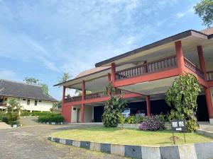 una casa roja con un cartel delante en SUPER OYO Flagship 90644 Cottage Nalendra Nuansa Nusantara, en Subang