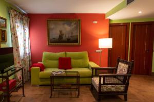 a living room with a green couch and red walls at Palacio Sirvente Mieres - PARKING GRATUITO in Andújar