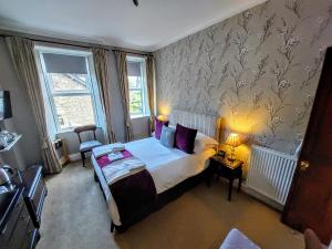 a bedroom with a bed with purple pillows at 1 Park Road in Windermere
