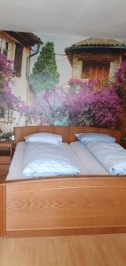 a wooden bed with two pillows on top of it at Hotel Gasthaus Felseneck in Staufenberg