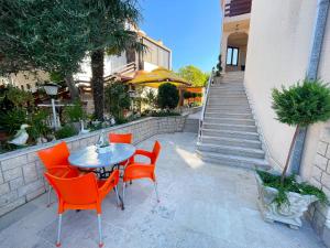 a table and chairs sitting in front of a building at Apartmani Selina in Jadranovo