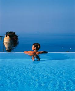 a man is in the water in a pool at Hotel Caesar Augustus in Anacapri
