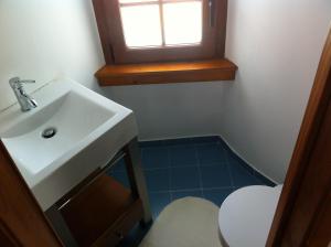 Un baño con lavabo, inodoro y ventana. en Moinho do Roque, en Lourinhã