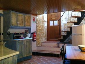cocina con escalera, mesa y nevera en Moinho do Roque, en Lourinhã