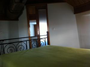 1 dormitorio con cama verde y balcón en Moinho do Roque, en Lourinhã