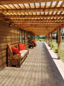Cunco casa de campo في تيموكو: بريغولا خشبي مع أريكتين على الفناء