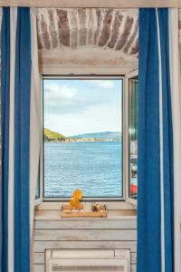 una ventana en una habitación con vistas al agua en Boutique Hotel Capitano, en Herceg-Novi