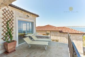 patio z krzesłem i balkonem z widokiem na ocean w obiekcie Vista Villas - Glory Nights Apartment Villa N w Ražancu