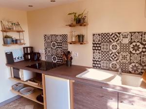 - une cuisine avec du carrelage noir et blanc sur le mur dans l'établissement Appartement avec vue sur les vignes à Gevrey, à Gevrey-Chambertin