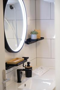 een badkamer met een wastafel en een spiegel bij Elégant appartement moderne - Cure et vacances in Balaruc-les-Bains