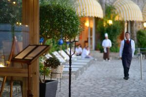 a man in a suit and tie walking down a sidewalk at Hotel Caesar Augustus in Anacapri +37 photos