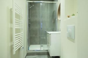 uma casa de banho branca com um chuveiro e um lavatório. em Apartment Parc des Expositions by Studio prestige em Paris